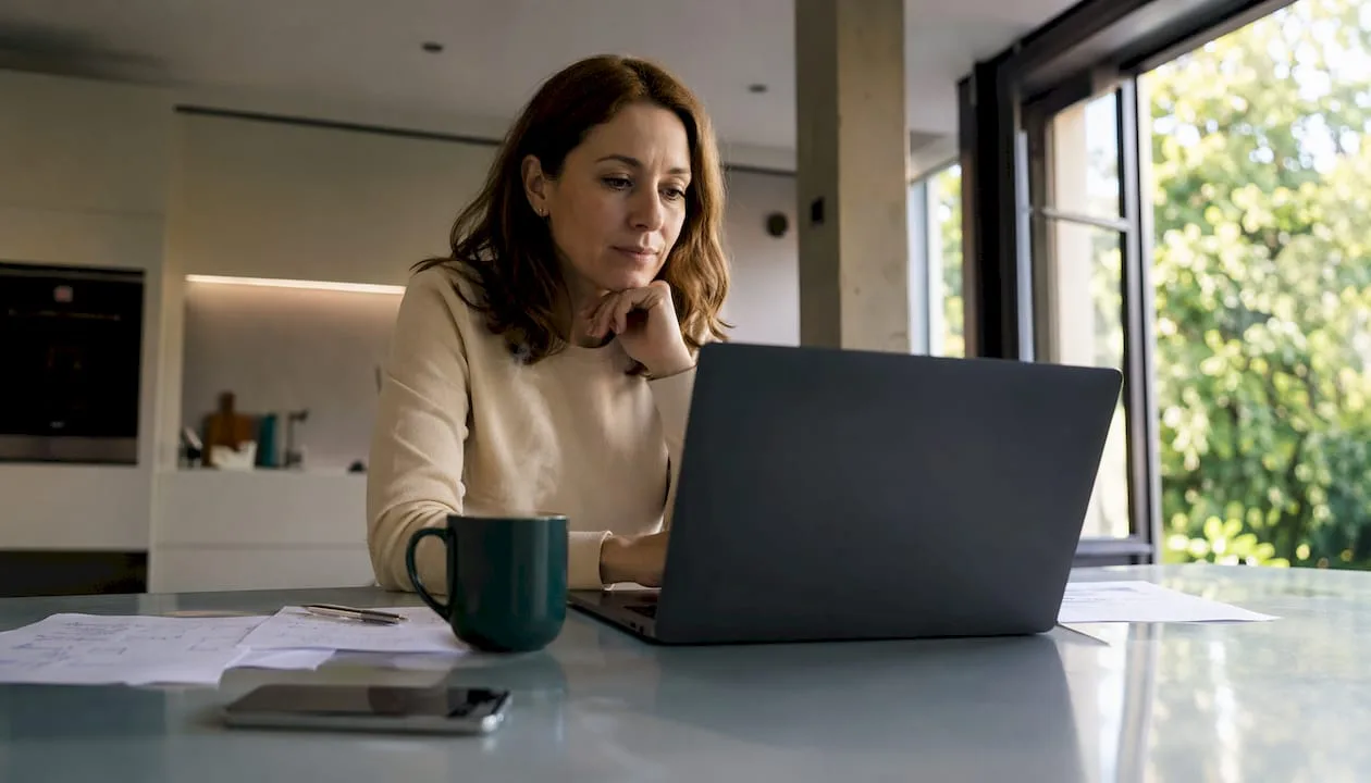 Eine Frau recherchiert am Laptop die aktuellen Hotelpreise und prüft den Preiskalender.
