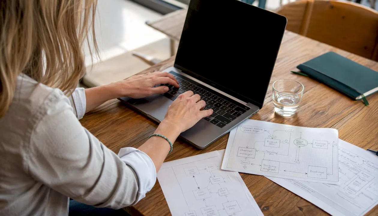 Ein Entwickler tippt am Laptop und arbeitet an der Integration einer Zahlungsabwicklung für Hotels.